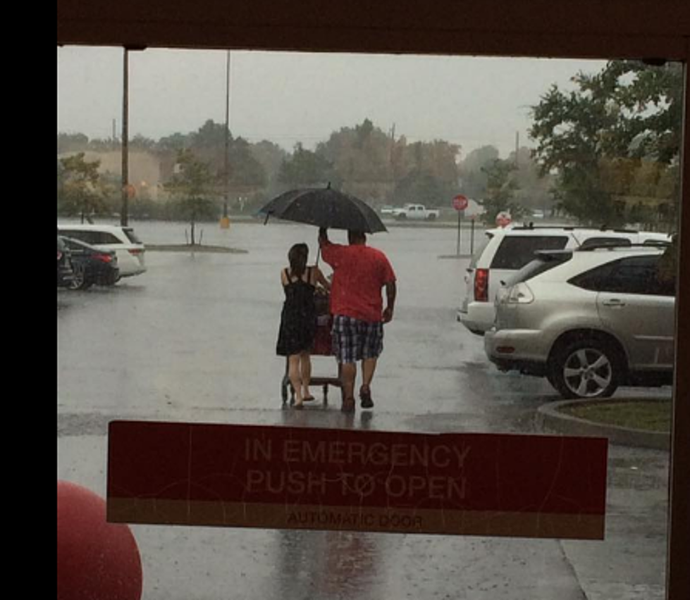 Kenner Man Escorts People With Umbrella During Rainstorm