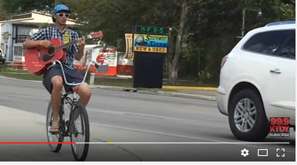Who Is This Guitar-Playing Bicyclist Seen On Pinhook? [VIDEO]