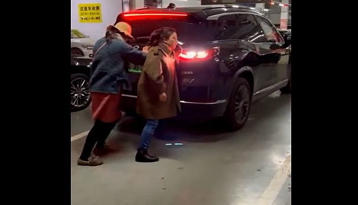 Women Stand in Parking Spot, Car Pushes Them Out of the