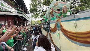 Louisiana Float Rider Holds up Important Sign During St. Patrick’s...