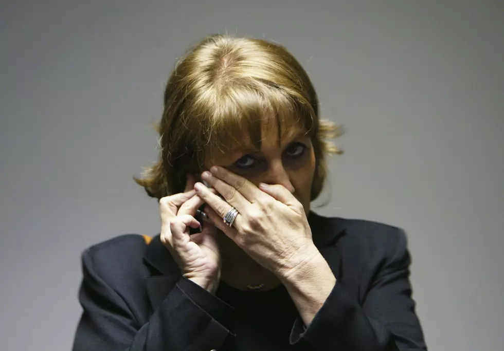 Woman on Phone, Limor Livnat covers her mouth with her hand as she speaks on the telephone