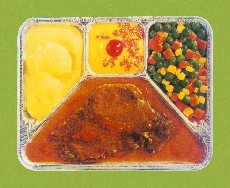 Vintage 1970s frozen TV dinner served in a classic compartmentalized foil tray with Salisbury steak and mixed vegetables.