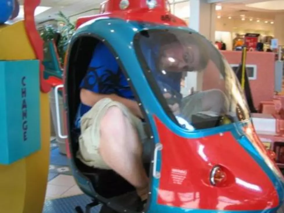 Giant Man Documents Efforts to Fit Inside Rides Designed for Children [PHOTOS]