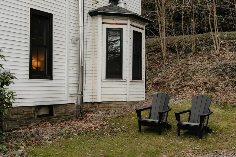Adirondack chairs next to a home
