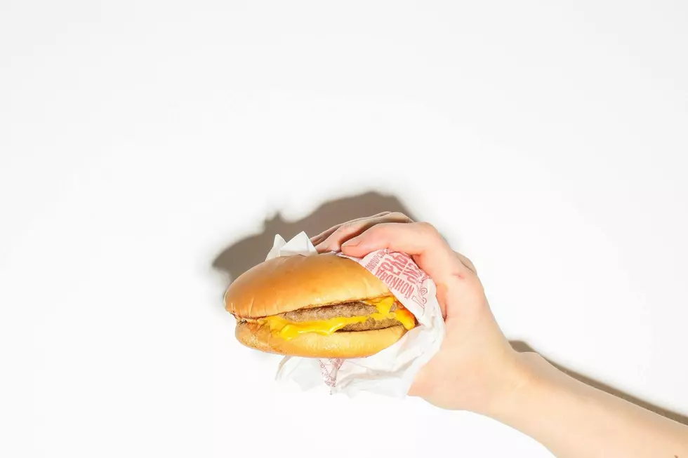 Hand holding a McDonald's burger in a wrapper