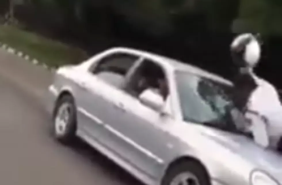 Cop Hanging Onto Hood Of Car Tries To Break Windshield With Helmet [Video]