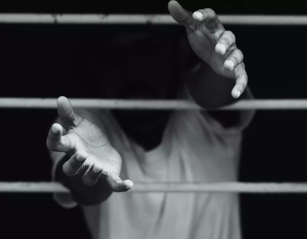 Hands Going Through Prison Bars
