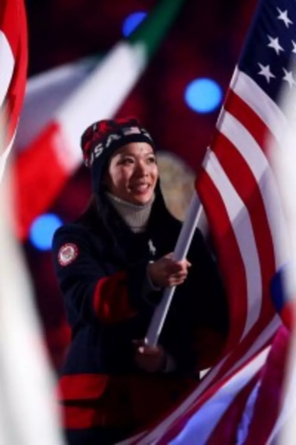 Hockey player Julie Chu of the United States enters with the flag during the 2014 Sochi Winter Olympics Closing Ceremony