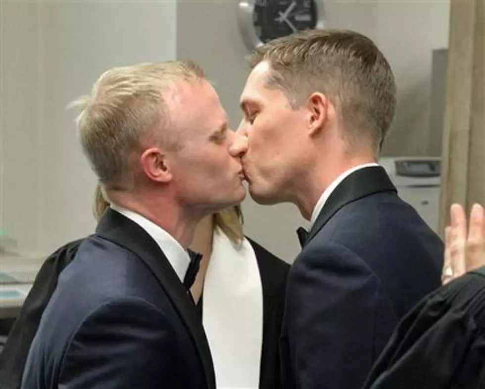 Gay couples wed on historic day as conservatives resist