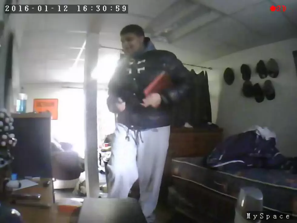Gun in one hand, iPad in another, smiling thief caught on camera
