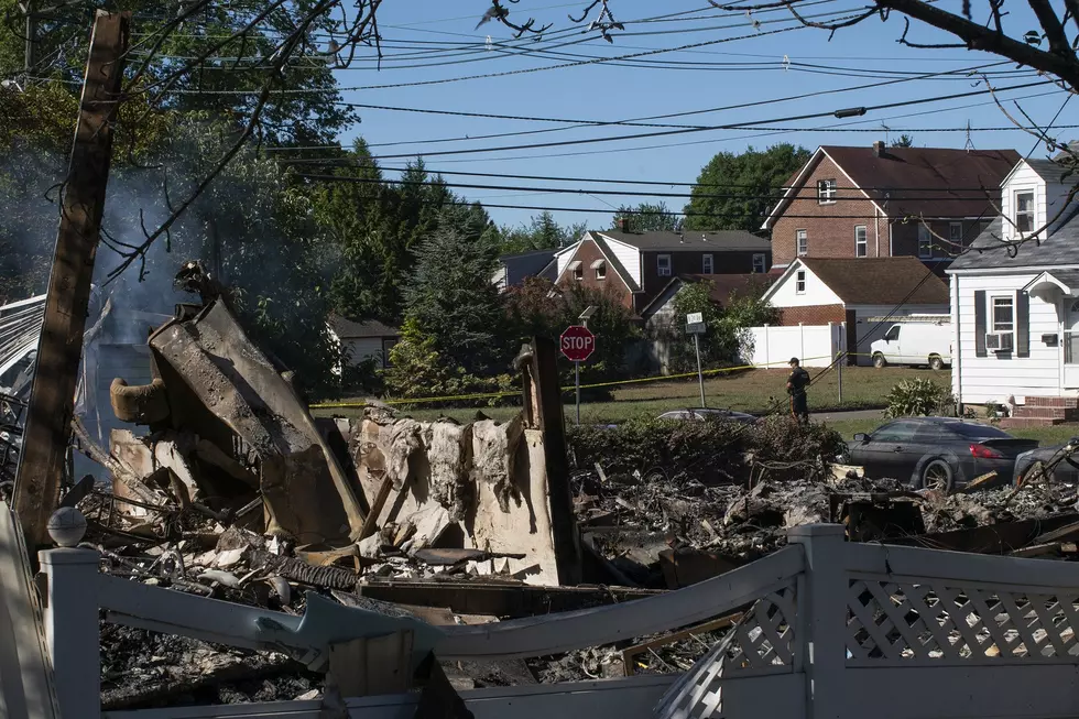 A Manville Police Officer stands guard near the remains of a house that exploded due to severe flooding from Tropical Storm Ida in Manville