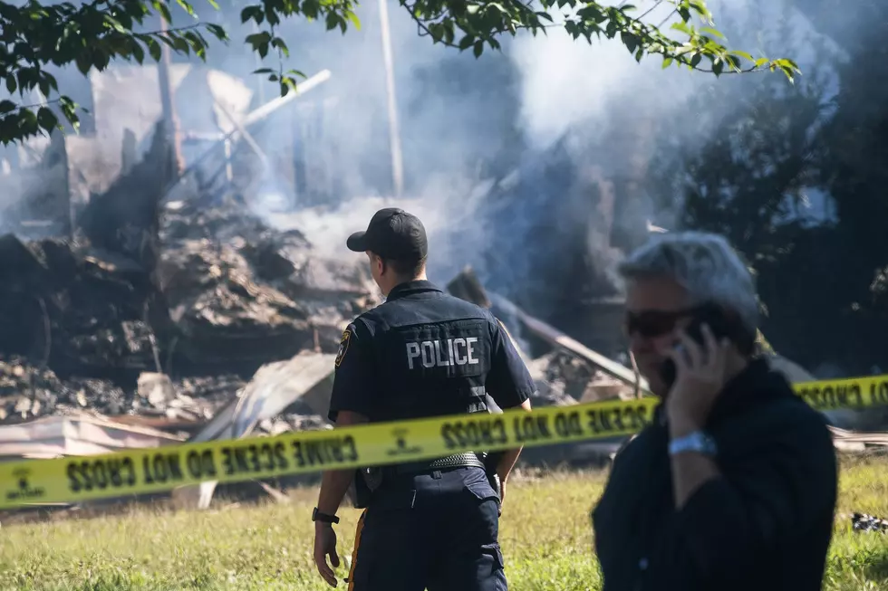 A Manville Police Officer stands guard near the remains of a house that exploded due to severe flooding from Tropical Storm Ida in Manville