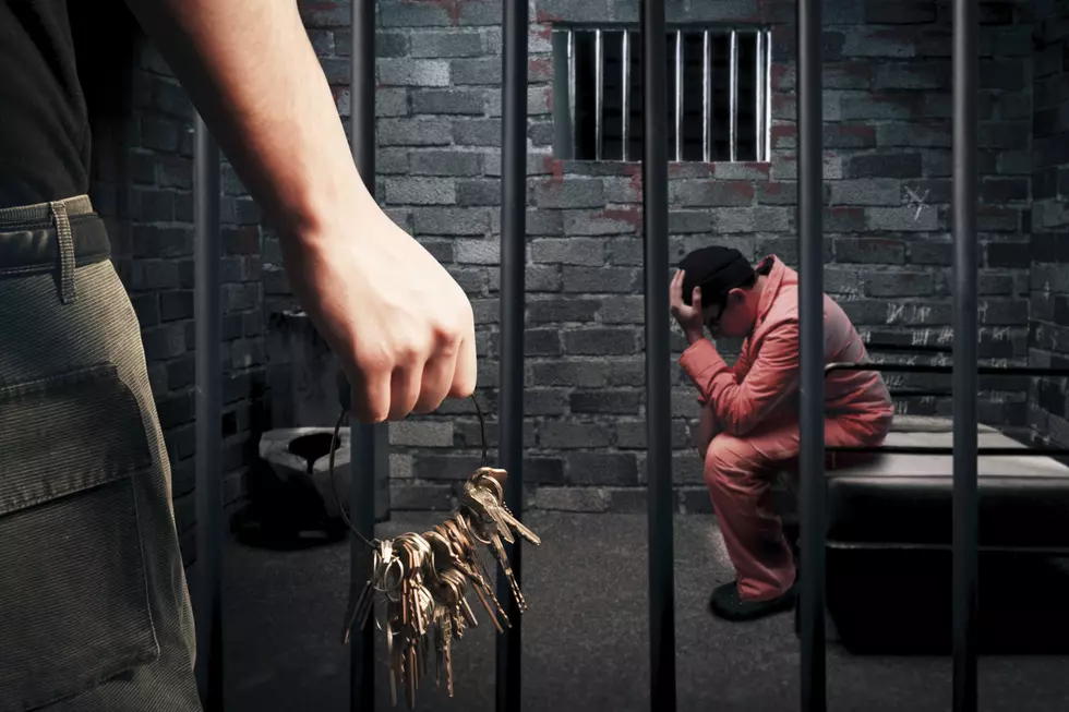 Prison guard with keys walking outside cell