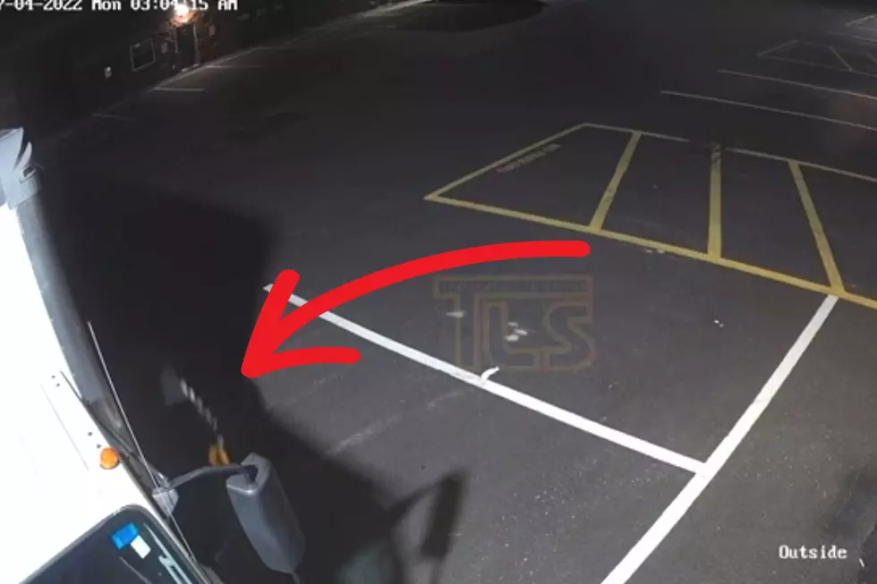Arrow points to person coming out from under a truck at a Lakewood industrial park.