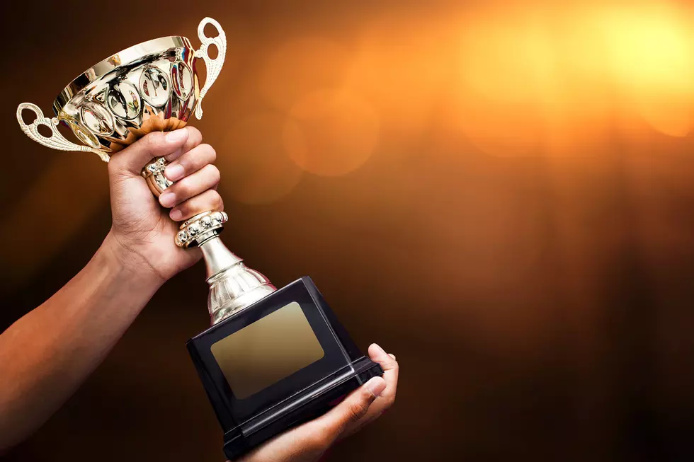 hand holding up a gold trophy cup as a winner in a competition