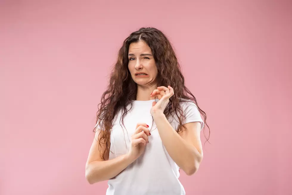 Young woman with disgusted expression repulsing something, isolated on the pink