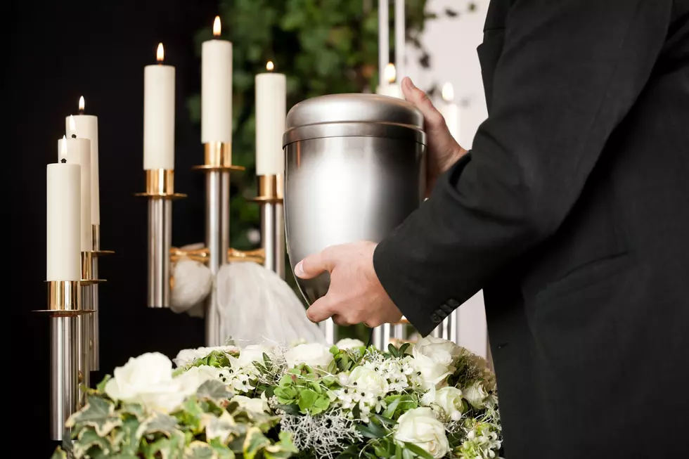 Religion, death and dolor - mortician on funeral with urn