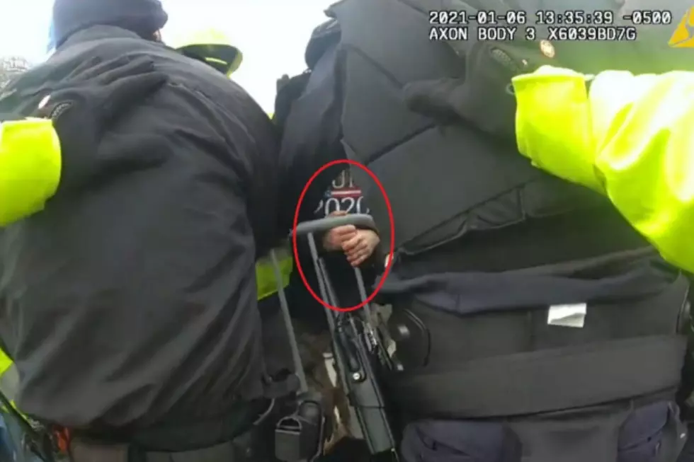 A man identified by federal prosecutors as Peter Krill moves a Capitol police barricade on Jan. 6, 2021. (DOJ)