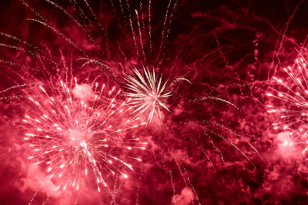 Explosions of red fireworks on the background on a dark night sky.