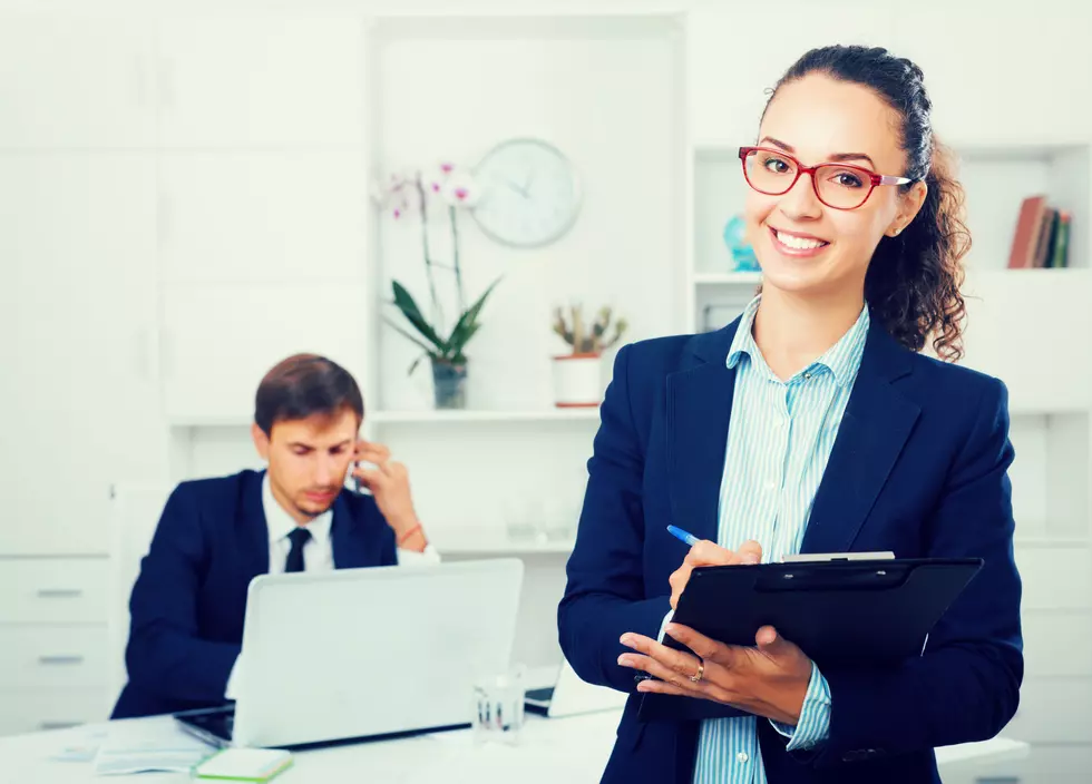 charming young woman manager holding cardboard in office