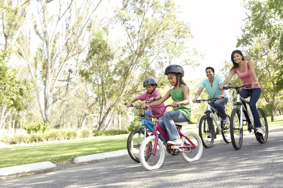 Young Family Riding Bikes In Park