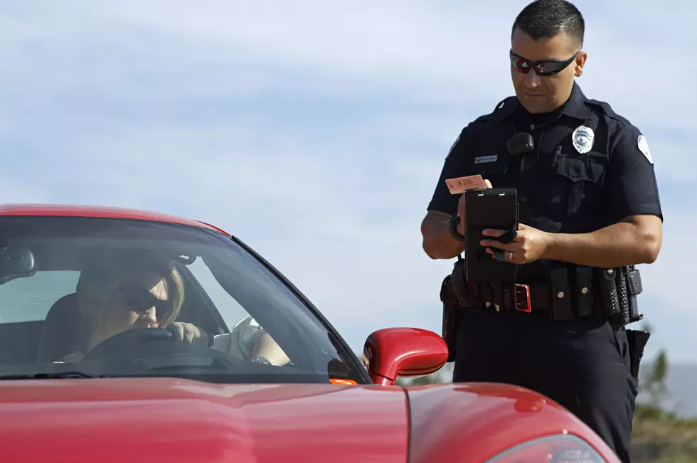 Traffic cop standing by sports car