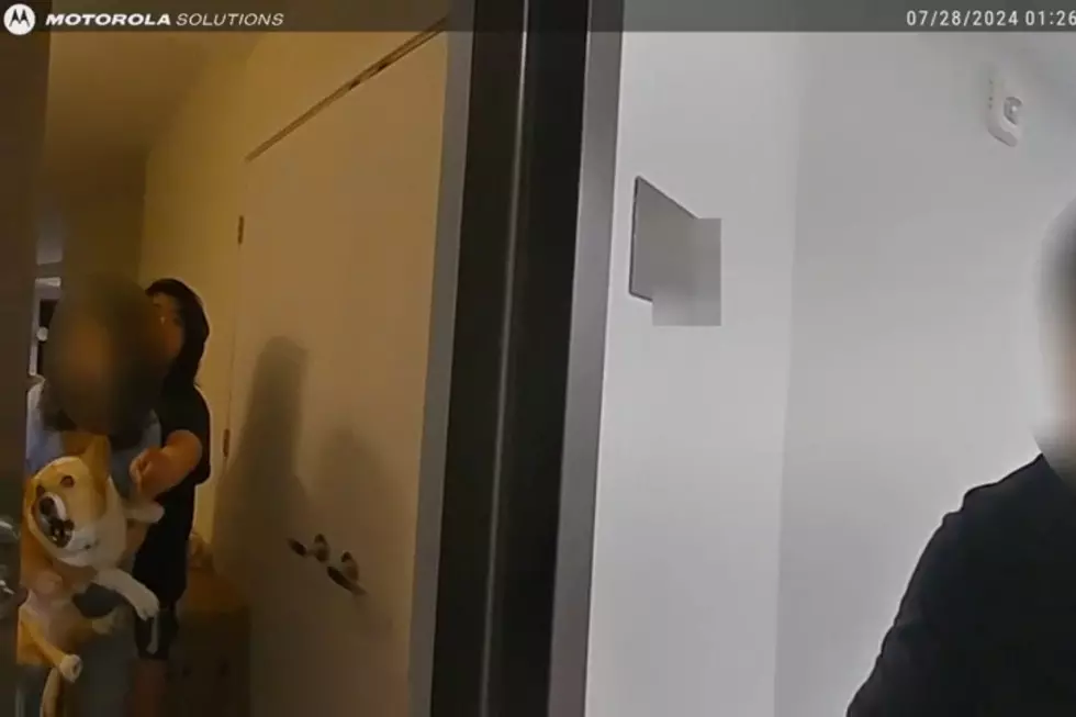 Victoria Lee's mother holds a dog as police open their apartment door. (OAG)