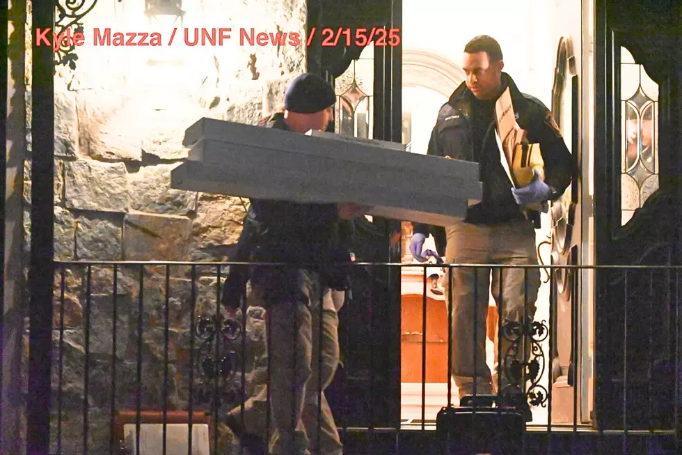 Crime scene unit investigators remove evidence bags and evidence boxes from a home in Wayne (Kyle Mazza/UNF News)