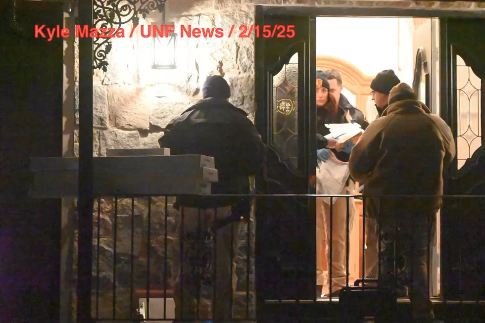 Crime scene unit investigators remove evidence bags and evidence boxes from a home in Wayne (Kyle Mazza/UNF News)