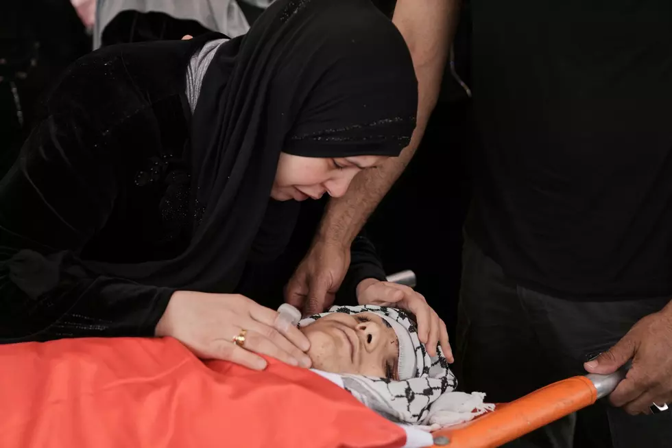 The mother of Amer Mohammed Rabie, a 14 year-old Palestinian-American shot by Israeli forces, takes a last look during his funeral in the West Bank town of Turmus Ayya, Monday, April 7, 2025. (AP Photo/Mahmoud Illean)