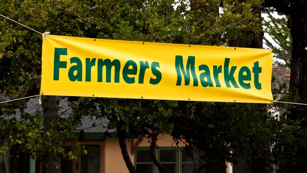 A yellow farmers market banner with green lettering.
