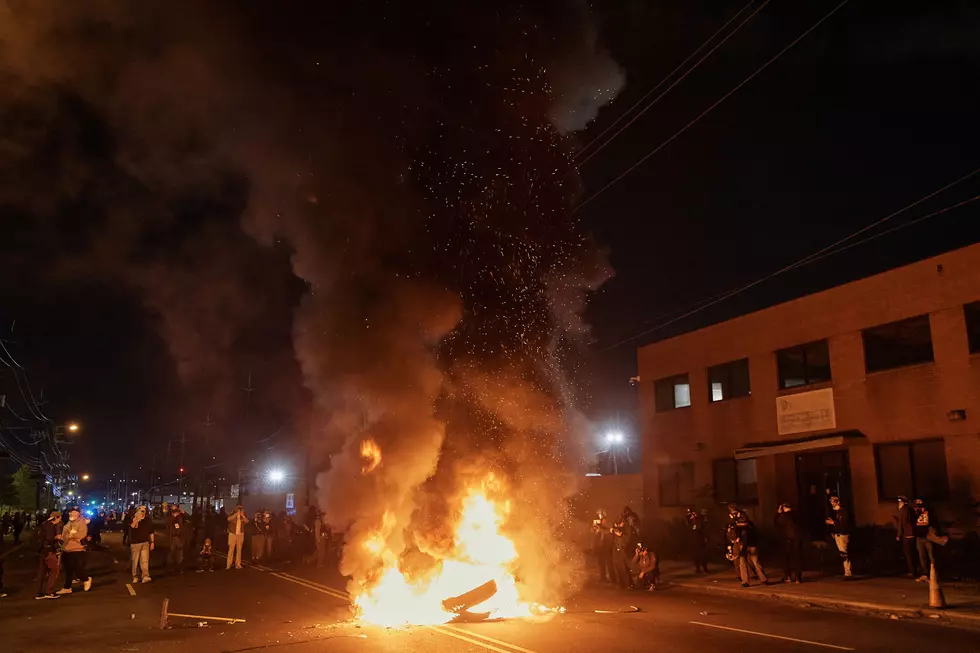 People watch a burning barricade near the Delaney Hall detention center during a protest against the transfer of detainees and federal immigration policies on Saturday, May 30, 2026, in Newark, N.J. (AP Photo/Andres Kudacki)