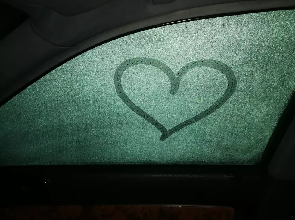 Painted heart on a dewy car window, view from inside, it's dark outside, image