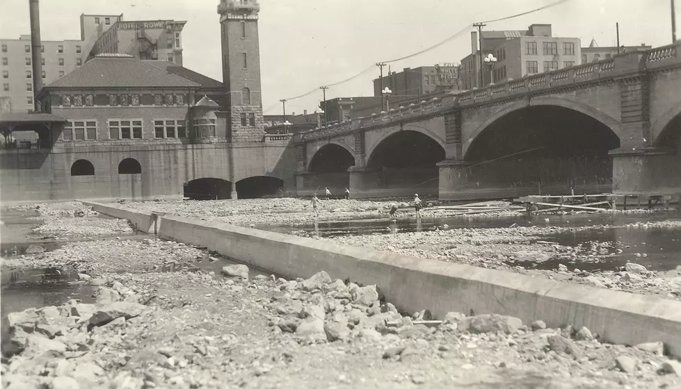 This photograph shows the Grand River and the dam just north of the Bridge St Bridge. The Rowe Hotel can be seen in the background.