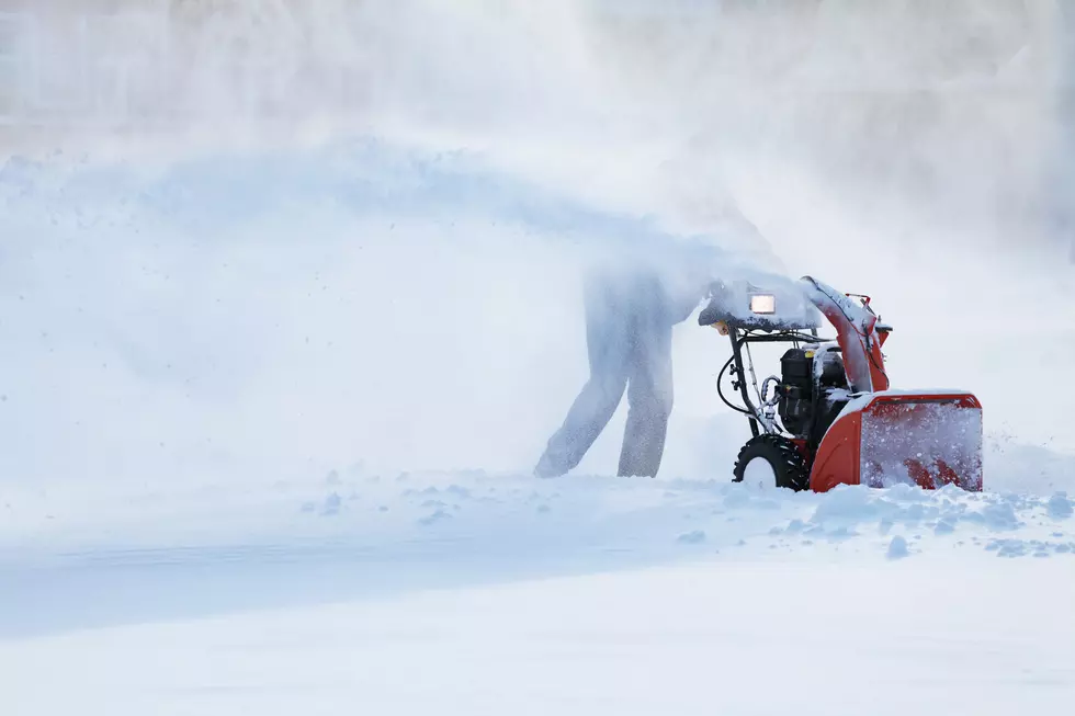 man with a snow blowing machine working in winter day