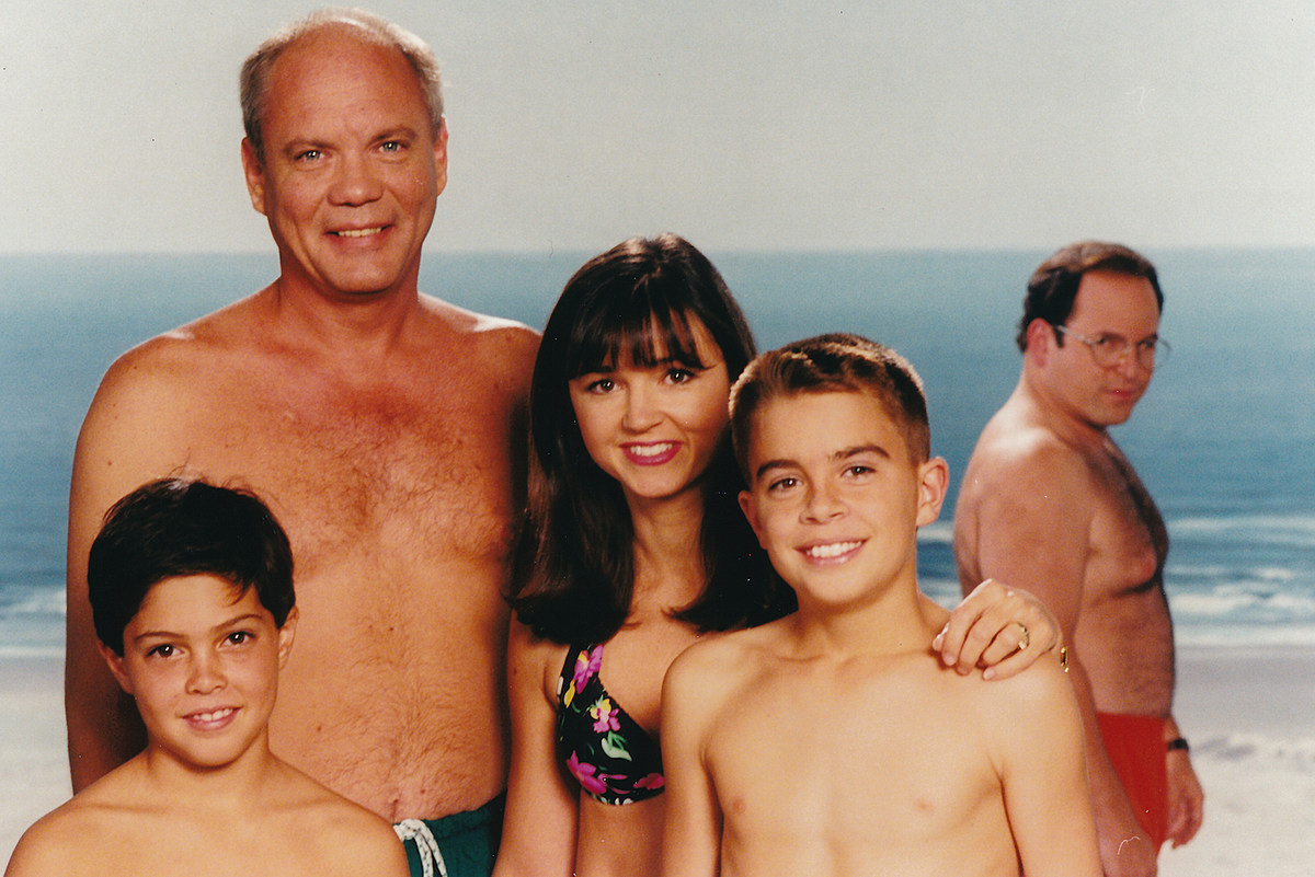 You know the photo – George Costanza photobombs his boss at the beach. 