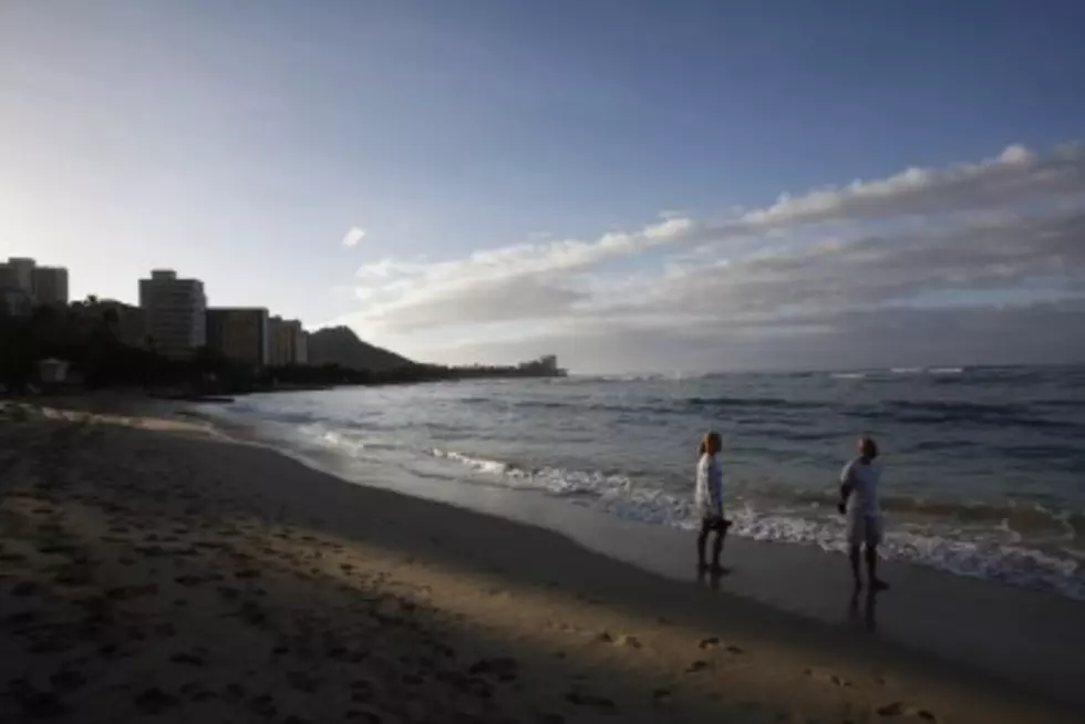 A couple strolls on Waikiki Beach. (Photo: Getty Images)