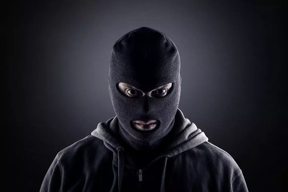 Criminal wearing black balaclava and hoodie in the dark