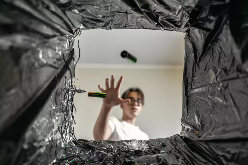 man throws batteries in the trash