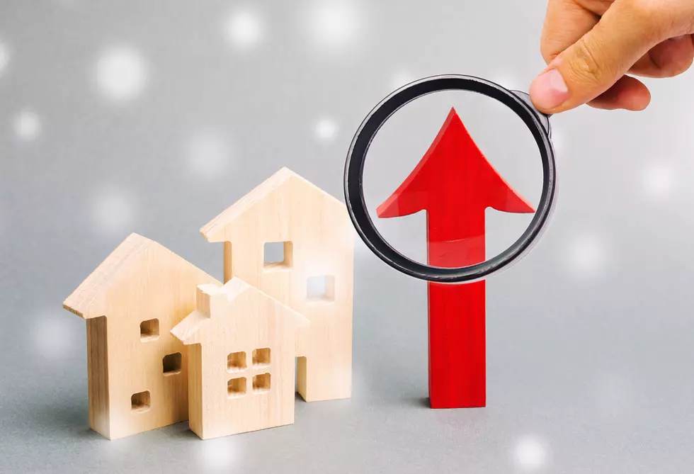Miniature wooden houses and up arrow with snowflakes. The concept of high housing demand. Investments for real estate in the winter. Mortgage interest rates. Expensive cost. Christmas market