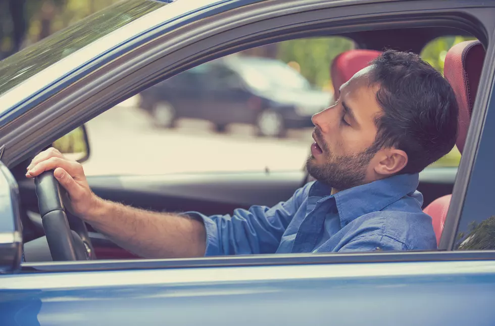 sleepy tired fatigued man driving car in traffic
