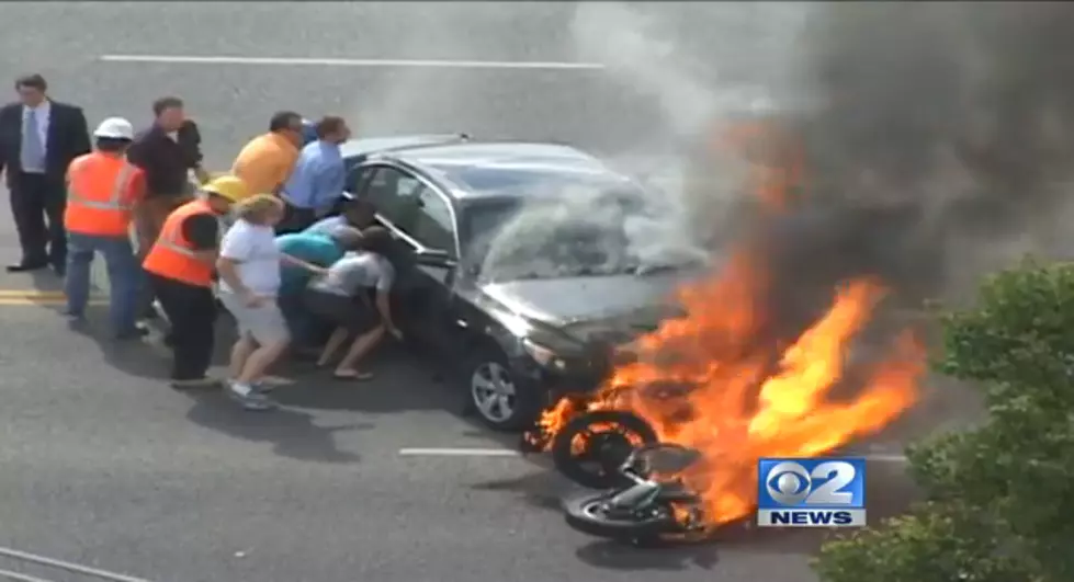 Amazing Rescue: Bystanders Lift Burning Car Off Injured Motorcyclist[VIDEO]