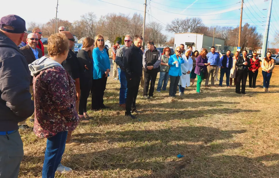 A small crowd to see a sign sign that shows what the future Boys & Girls Club Teen Center will look like, according to an architectural drawing, during a brief ceremony held Wednesday morning in the 600 block of East Third Street.