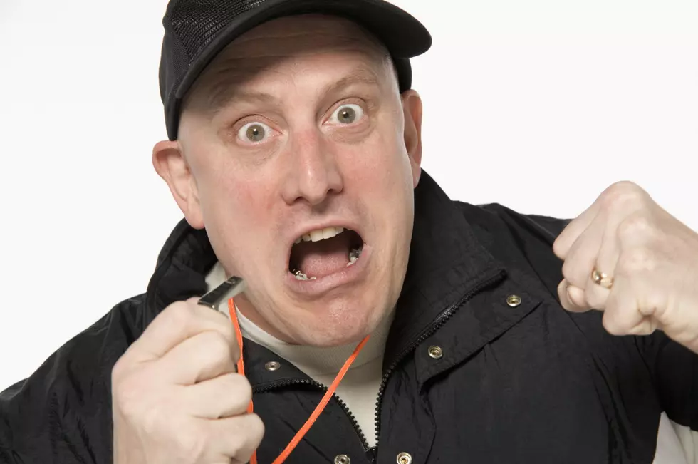 Man holding whistle while yelling