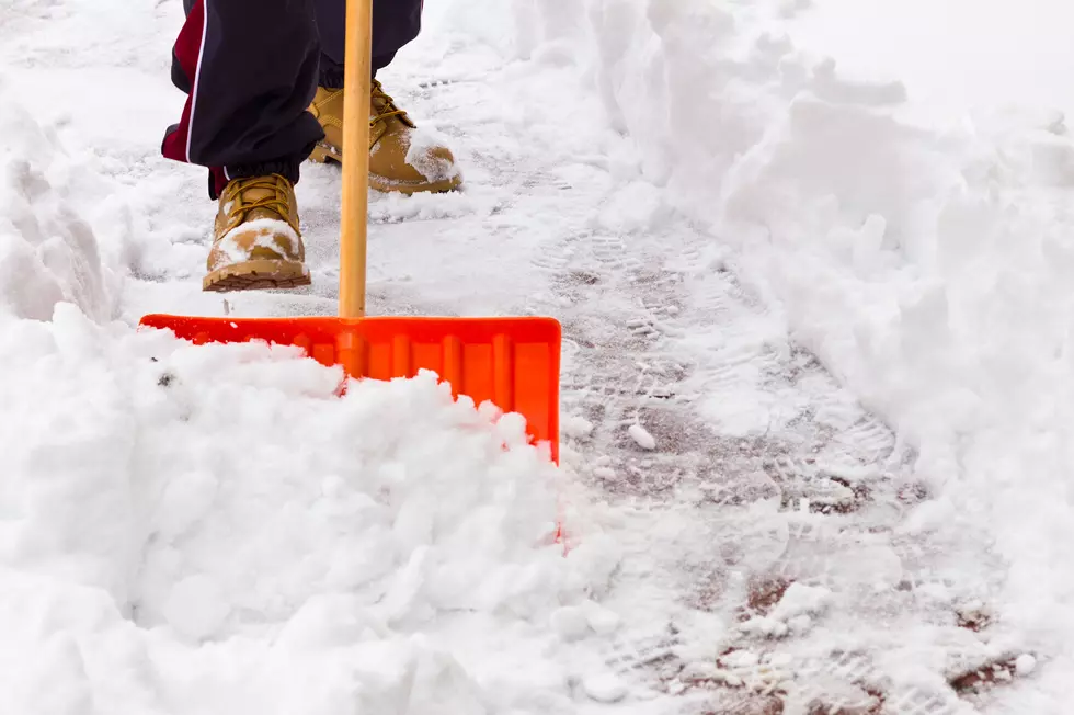 Close-up of shovel as man clears snow from path