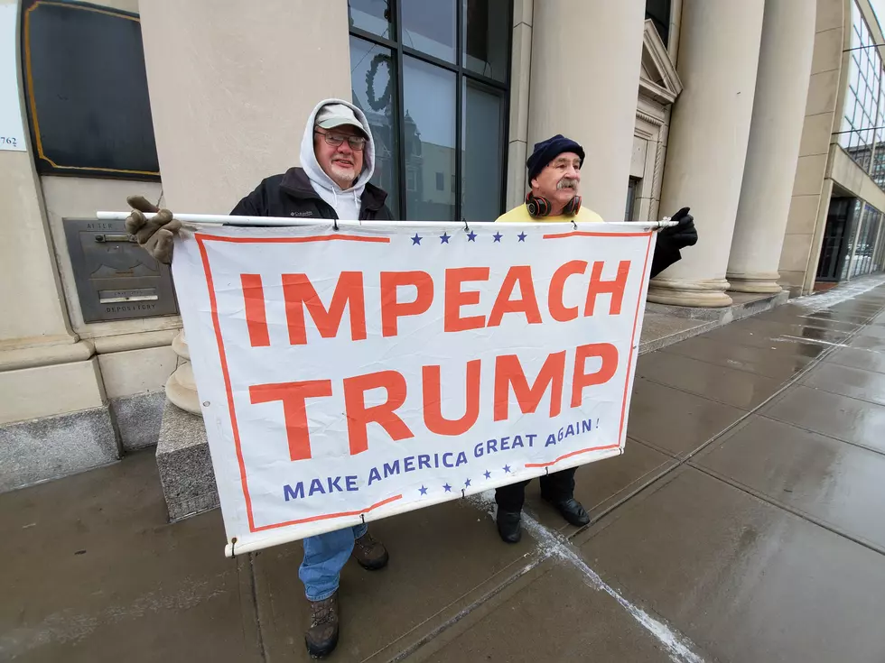 Two men held a sign at a demonstration in downtown Binghamton on December 17, 2019. (Photo: Bob Joseph/WNBF News)