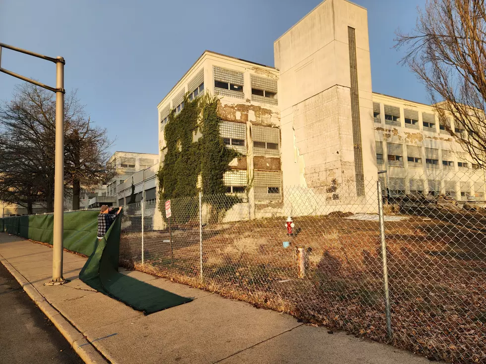 A worker installed a green covering on a North Street fence in preparation for the upcoming demolition of old IBM Endicott buildings. (Photo: Bob Joseph/WNBF News)