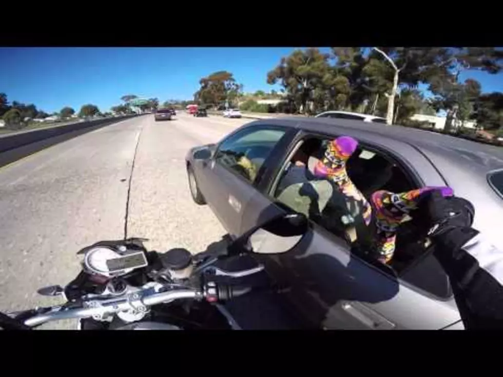 Person With Legs Hanging Out of Car Window Gets Hilarious Surprise From Motorcyclist
