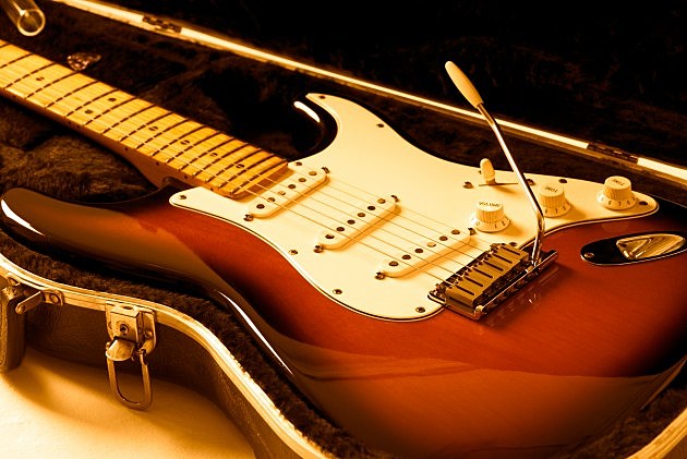 Electric guitar on case with orange lighting.