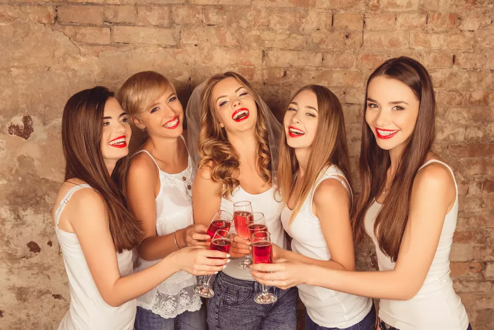 Attractive bride and happy bridesmaids celebrating hen-party wit